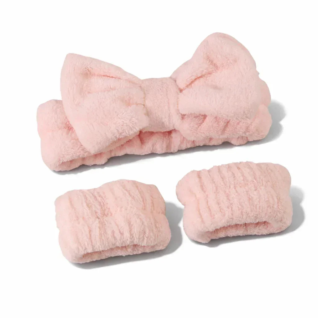 Soft pink plush headband with bow and matching wristbands set on white background